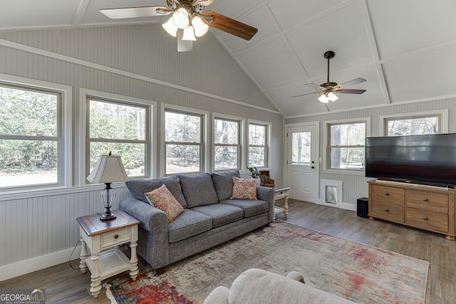 living area with plenty of natural light, vaulted ceiling, baseboards, and wood finished floors