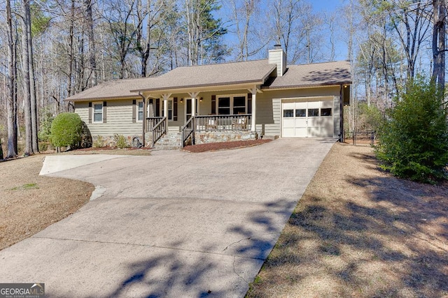 ranch-style house with roof with shingles, a chimney, a porch, concrete driveway, and a garage