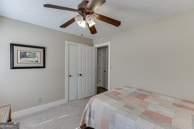 carpeted bedroom with ceiling fan and baseboards