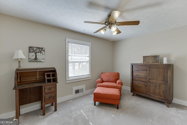 sitting room featuring baseboards, visible vents, light carpet, and a textured ceiling