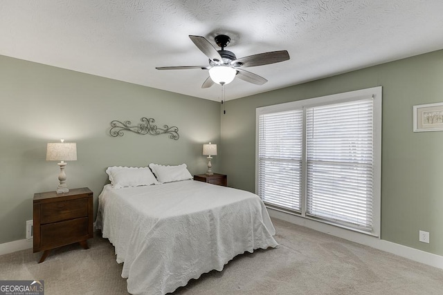 bedroom with a textured ceiling, baseboards, a ceiling fan, and light colored carpet