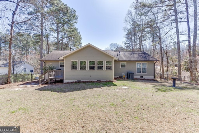 rear view of house with crawl space, a lawn, and fence