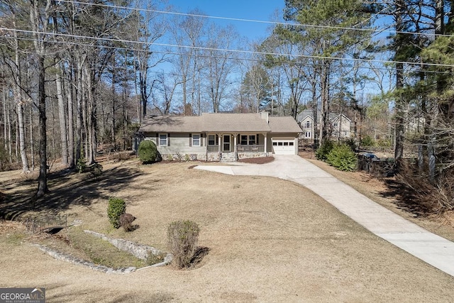 view of front of home with an attached garage, a chimney, and concrete driveway