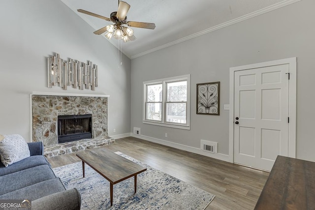 living room with visible vents, vaulted ceiling, wood finished floors, and ornamental molding