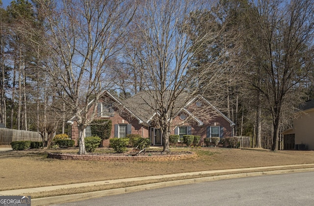 view of front facade with brick siding and fence