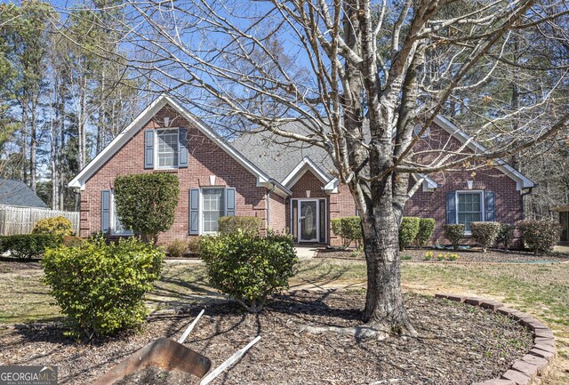 view of front facade with fence and brick siding