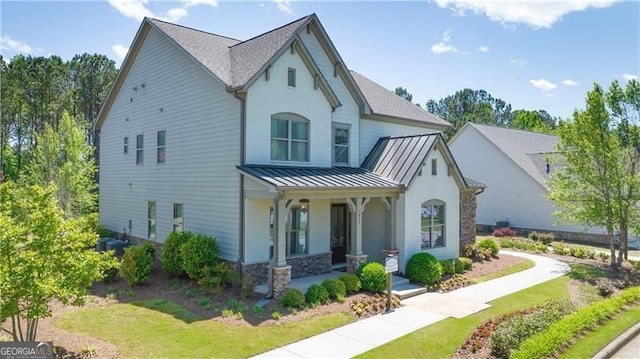 view of front facade featuring a standing seam roof, metal roof, and covered porch