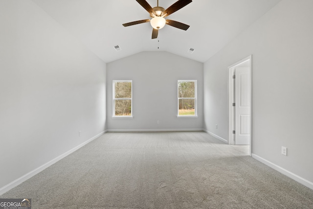 carpeted empty room with visible vents, vaulted ceiling, baseboards, and ceiling fan