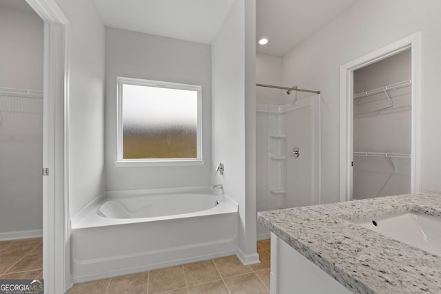 full bathroom with a spacious closet, a shower, a bath, and tile patterned floors