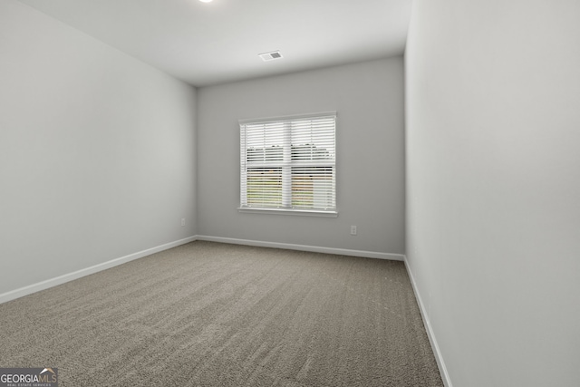 carpeted empty room featuring visible vents and baseboards