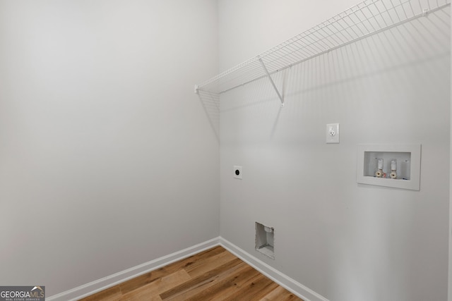 laundry area featuring laundry area, baseboards, light wood-type flooring, washer hookup, and electric dryer hookup