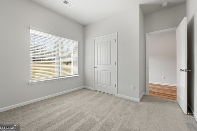 unfurnished bedroom featuring carpet, baseboards, and visible vents