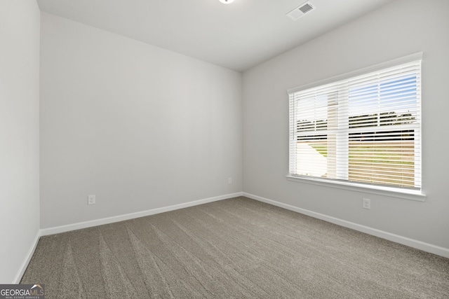 carpeted empty room featuring visible vents and baseboards