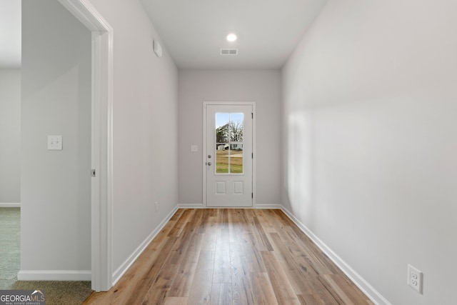 doorway to outside featuring visible vents, light wood-style flooring, and baseboards