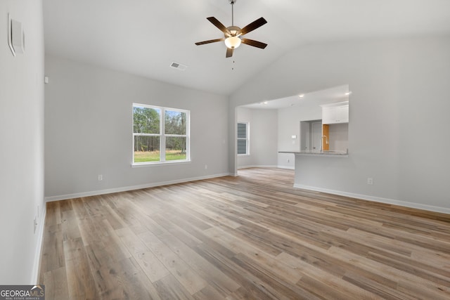 unfurnished living room with high vaulted ceiling, a ceiling fan, baseboards, visible vents, and light wood-style floors