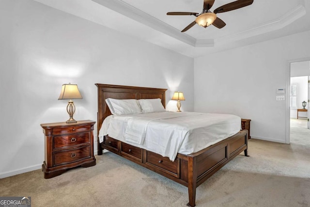 bedroom with light carpet, baseboards, a raised ceiling, and ornamental molding