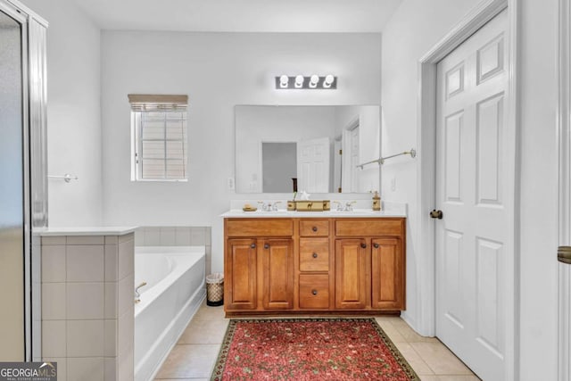 bathroom featuring tile patterned flooring, a shower with shower door, a sink, a bath, and double vanity