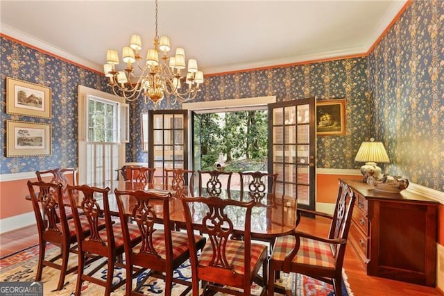 dining area featuring wallpapered walls, wood finished floors, baseboards, and a chandelier