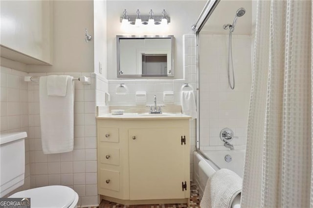 full bath with tile walls, toilet, wainscoting, vanity, and shower / bathtub combination with curtain