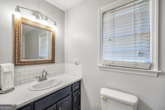 bathroom with vanity, backsplash, and toilet