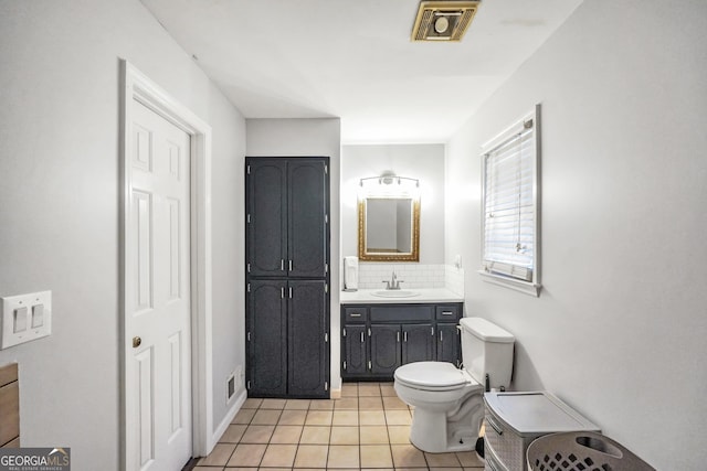 bathroom with visible vents, toilet, tile patterned floors, vanity, and backsplash