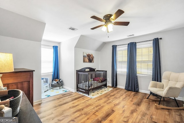 bedroom featuring multiple windows, wood finished floors, and baseboards