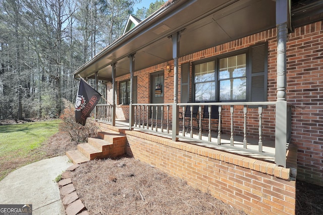 exterior space with covered porch and brick siding