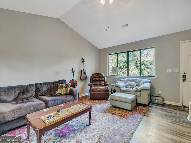 living room with lofted ceiling, wood finished floors, visible vents, and baseboards