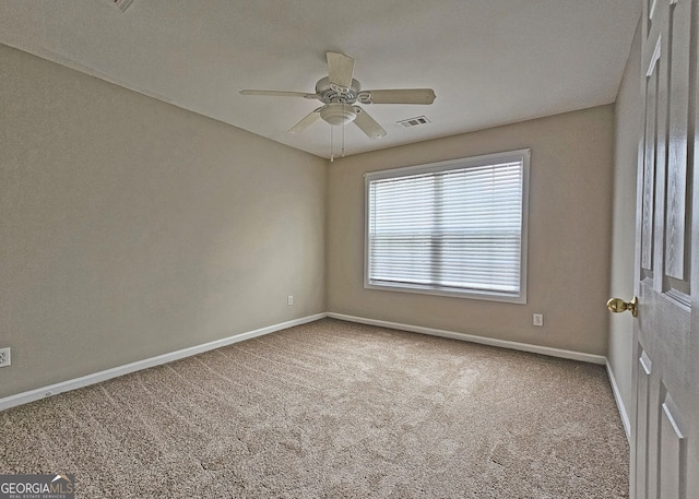 carpeted spare room with ceiling fan, visible vents, and baseboards