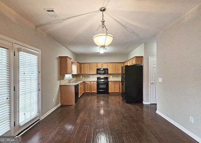 kitchen featuring visible vents, backsplash, dark wood-style flooring, black appliances, and a sink