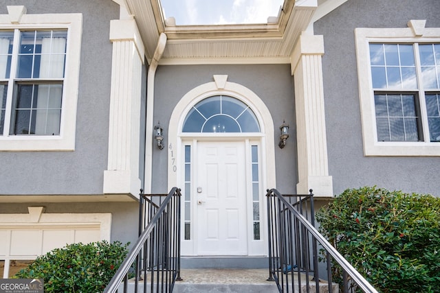 view of exterior entry featuring stucco siding