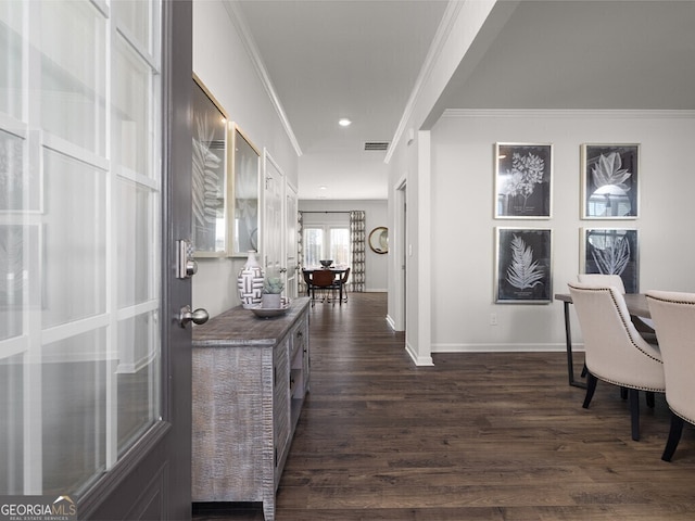 hallway with baseboards, visible vents, dark wood finished floors, and crown molding