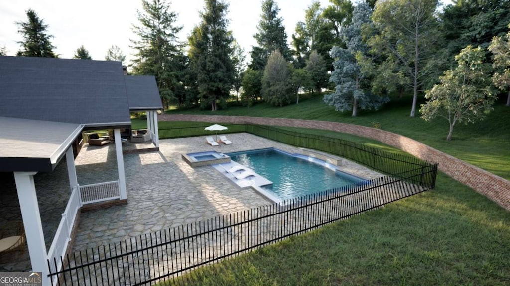 view of swimming pool featuring a yard, a patio, fence, and a pool with connected hot tub