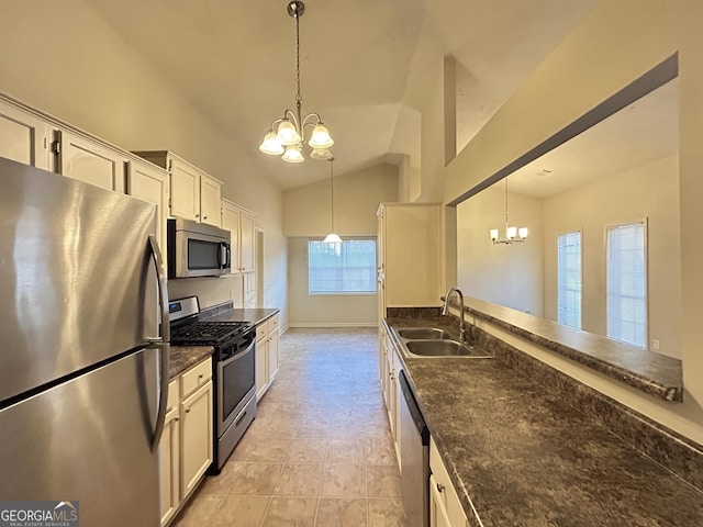 kitchen with an inviting chandelier, vaulted ceiling, stainless steel appliances, and a sink