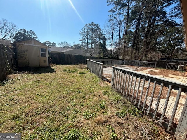 view of yard featuring a storage unit, an outdoor structure, and a fenced backyard