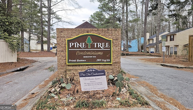 community sign featuring driveway and a residential view