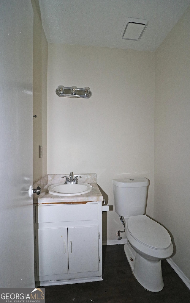 bathroom with toilet, baseboards, visible vents, and vanity