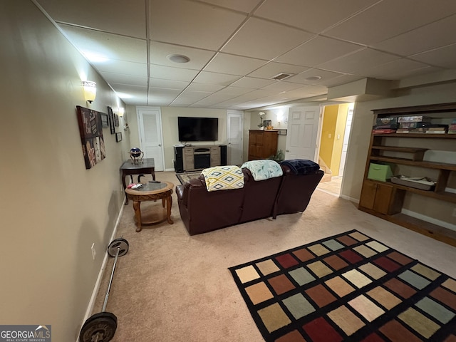 carpeted living area featuring visible vents, a paneled ceiling, and baseboards