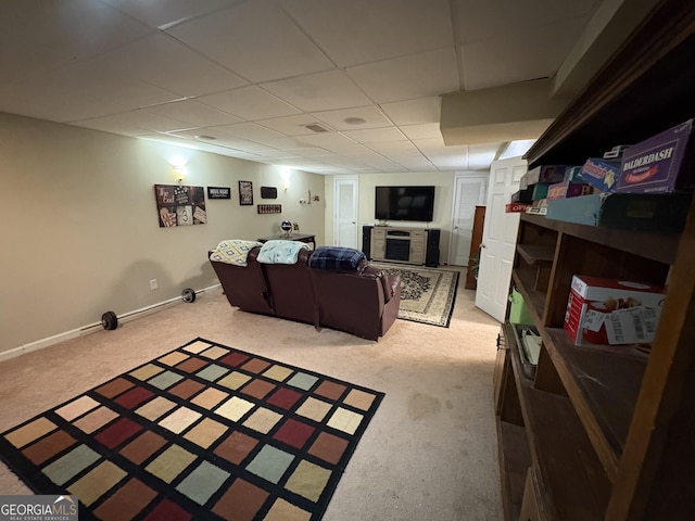 interior space featuring a paneled ceiling, light carpet, and baseboards