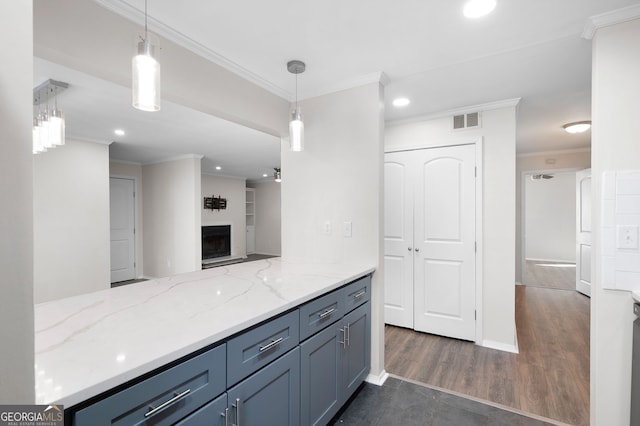 kitchen featuring light stone counters, a fireplace, visible vents, hanging light fixtures, and crown molding