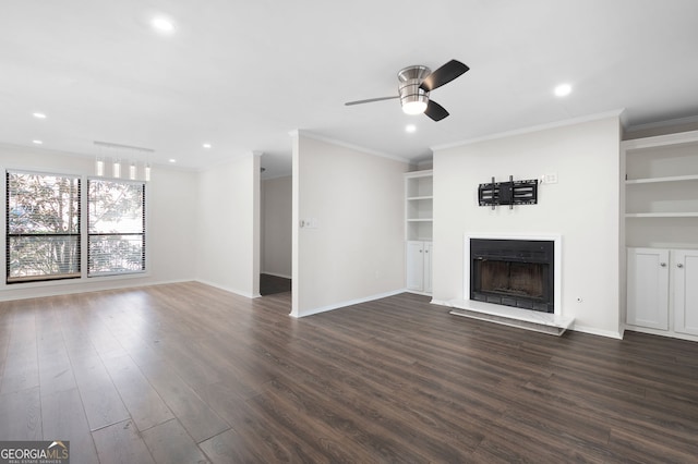 unfurnished living room with crown molding, a fireplace with raised hearth, dark wood finished floors, and baseboards