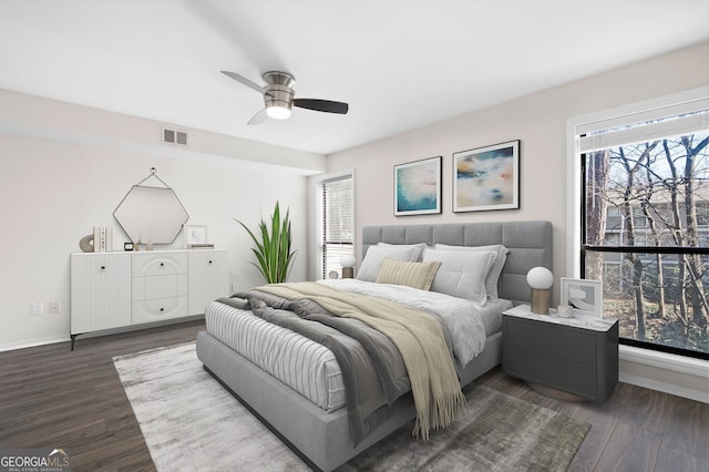 bedroom featuring dark wood-style floors, baseboards, visible vents, and ceiling fan