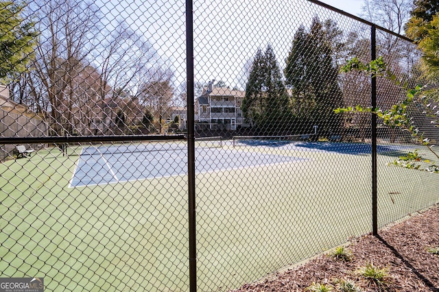 view of tennis court featuring fence