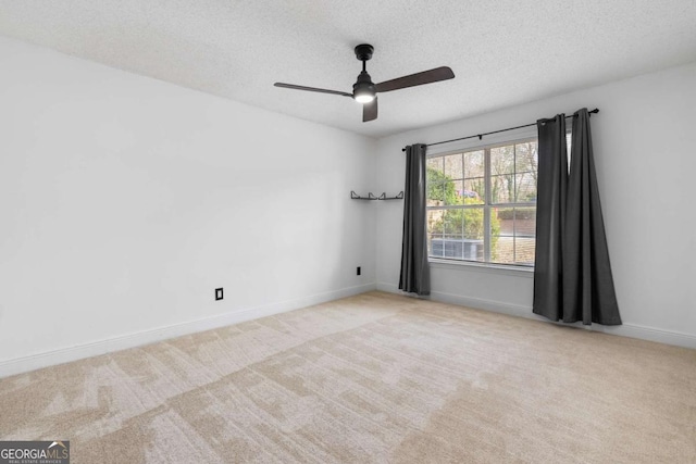 unfurnished room with carpet floors, ceiling fan, a textured ceiling, and baseboards