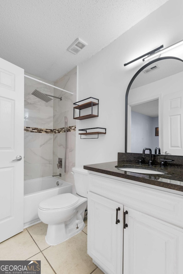 bathroom with a textured ceiling, toilet, vanity, visible vents, and tile patterned floors