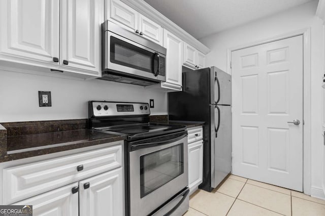 kitchen with white cabinetry, stainless steel appliances, and light tile patterned flooring