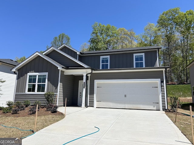 view of front of property with board and batten siding, concrete driveway, and an attached garage