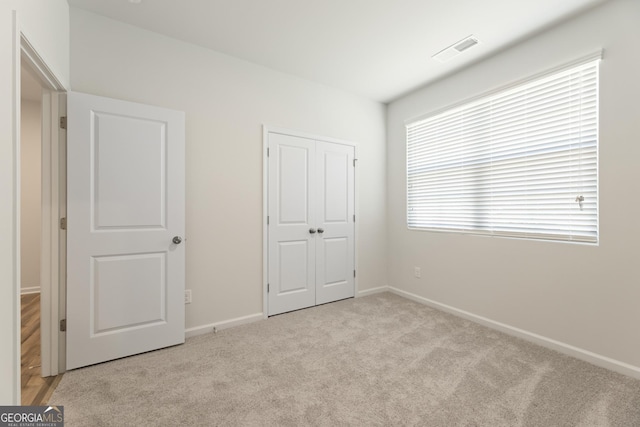 unfurnished bedroom featuring carpet floors, baseboards, and a closet