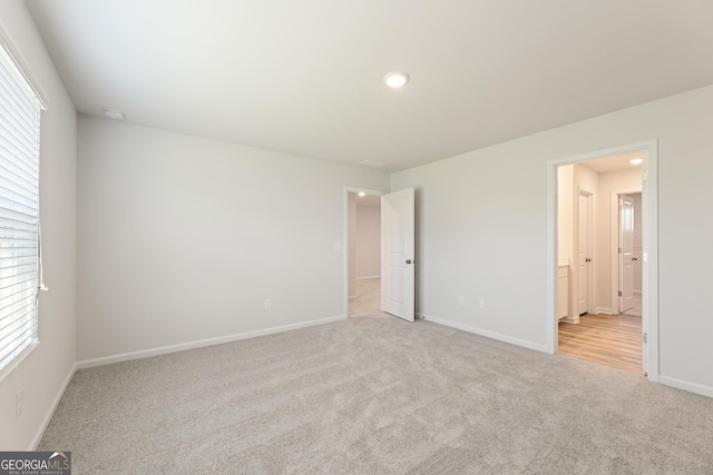 unfurnished bedroom with carpet floors, baseboards, multiple windows, recessed lighting, and connected bathroom