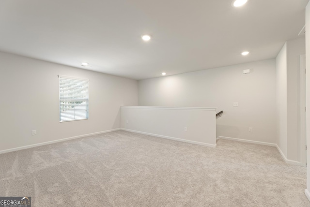 below grade area featuring recessed lighting, light colored carpet, and baseboards